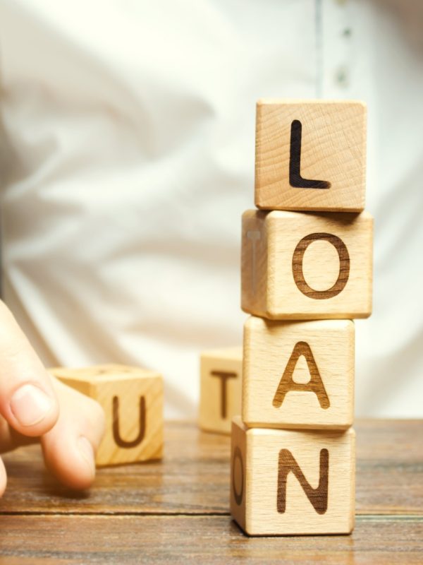 Wooden blocks with the word loan and businessman